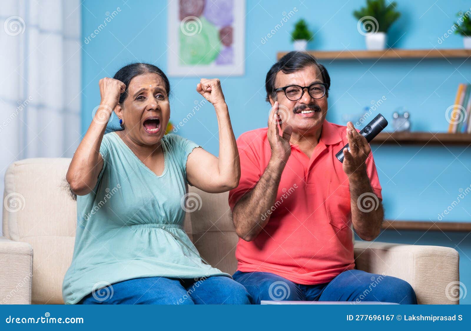Happy Excited Indian Senior Couple Watching Live Cricket Sports Match on Tv or Television while Sitting on Sofa at Home Stock Image