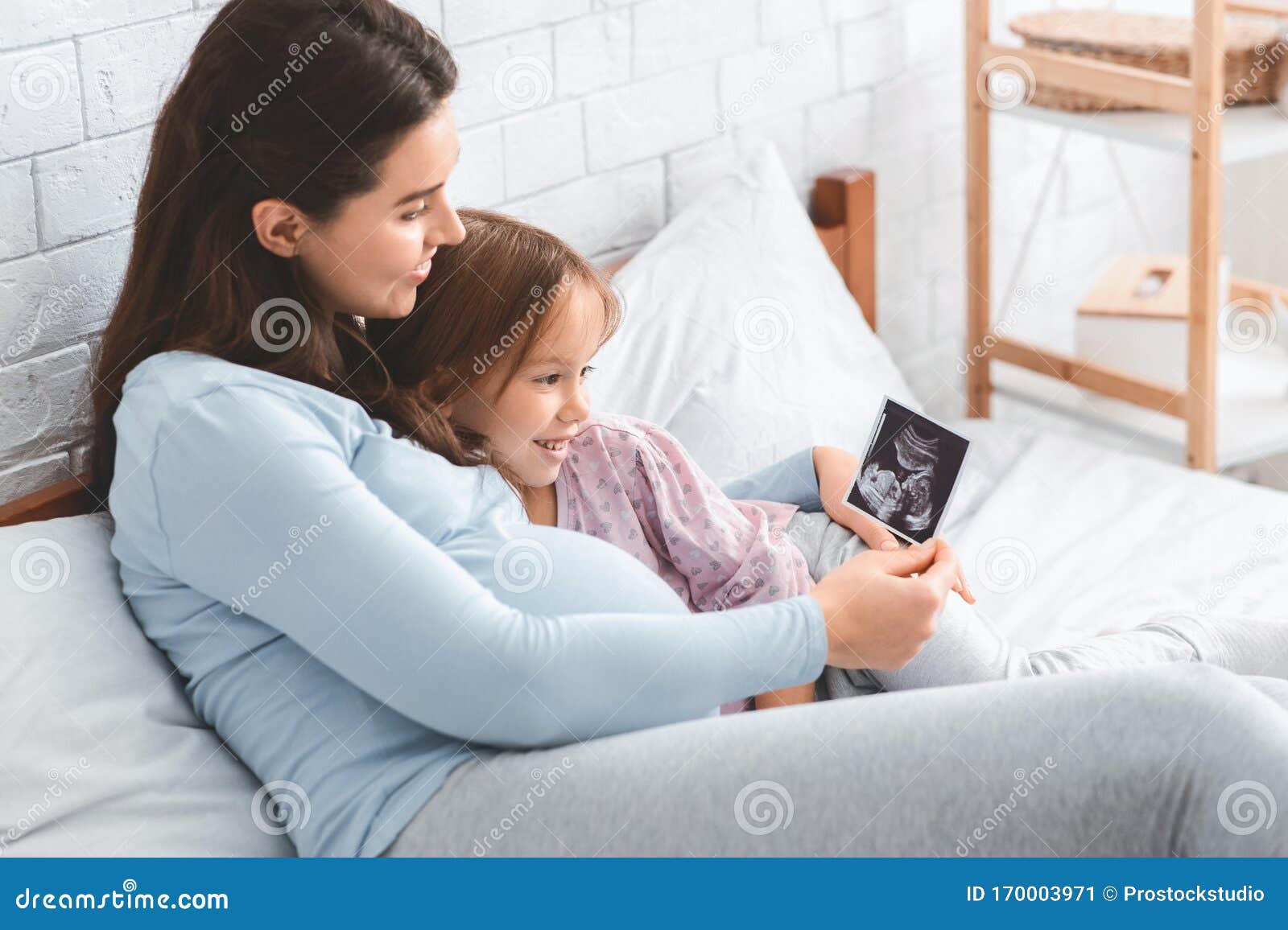 As If Daughter Scan Expecting Woman Showing Ultrasound Scan To Her Daughter Stock Image