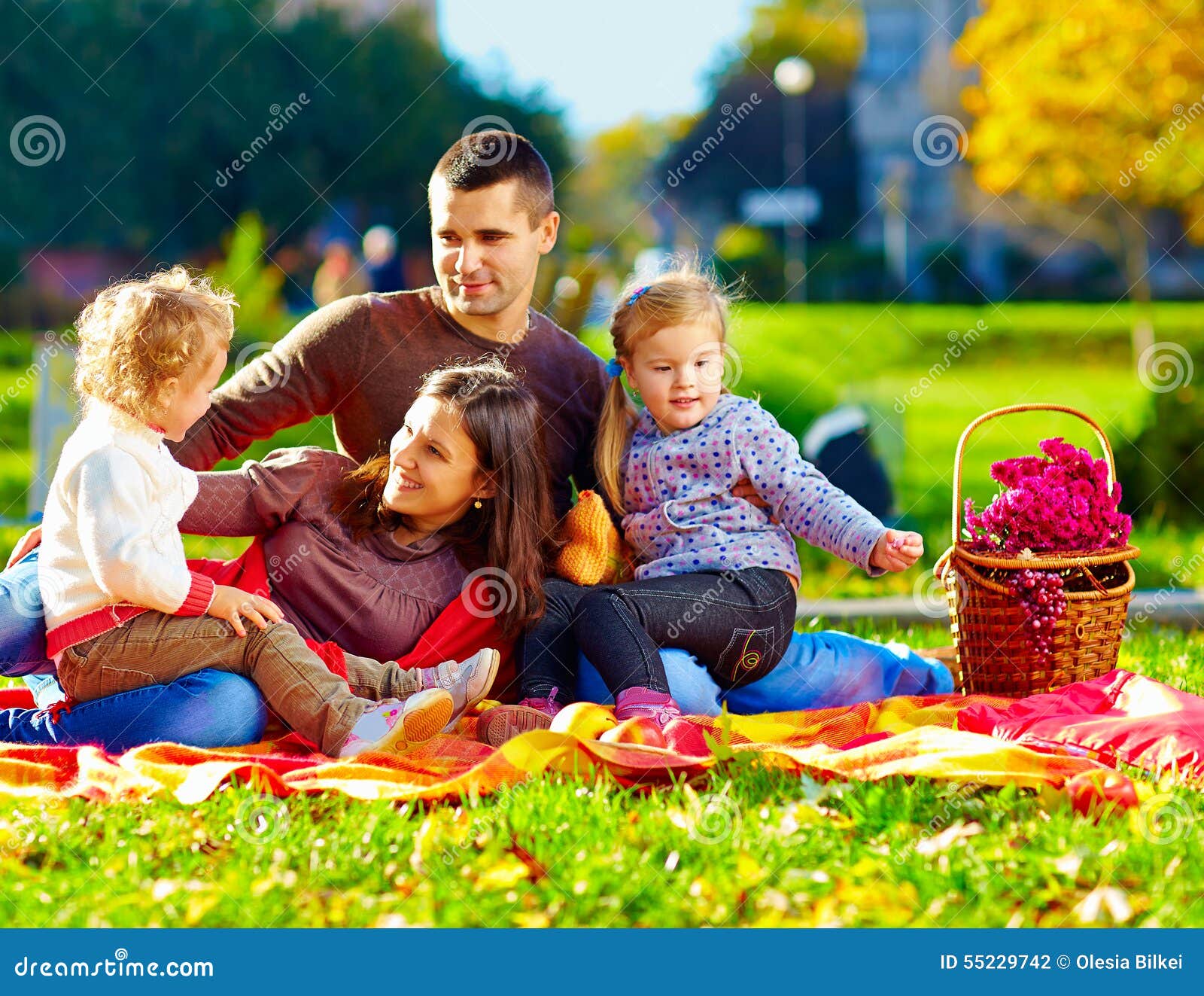 Happy family on the autumn picnic in park