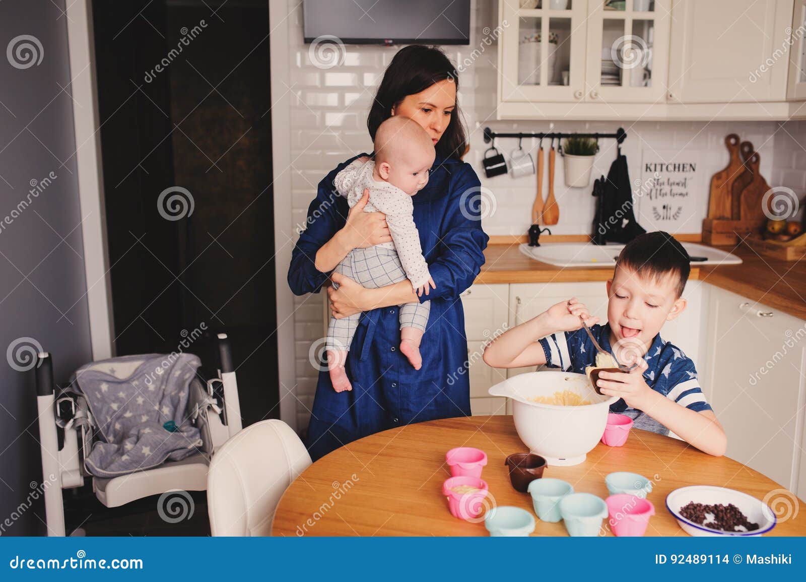 Happy Family Baking Together in Modern White Kitchen. Mother, Son and
