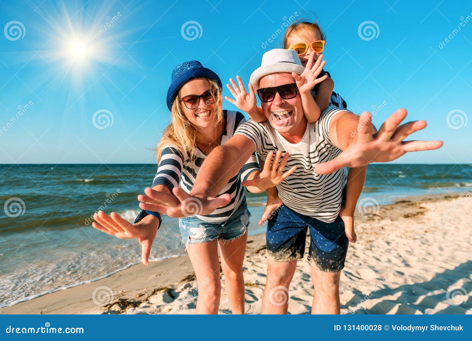 happy family on the beach. people having fun on summer vacation. father, mother and child against blue sea and sky background.