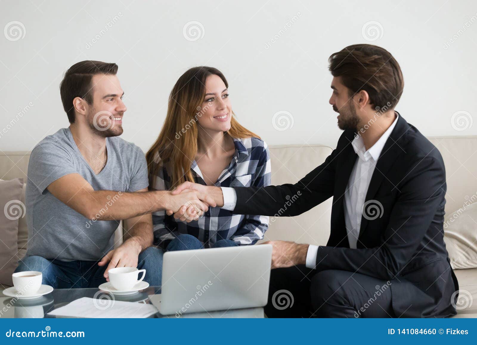 happy family couple renters tenants handshaking realtor landlord at meeting