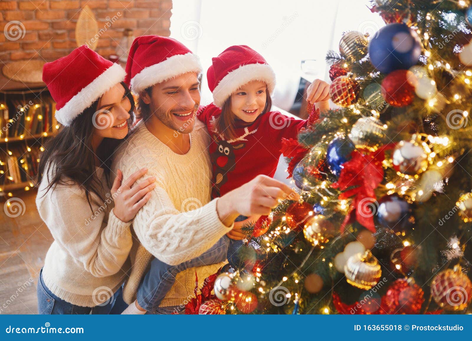 happy family decorating christmas tree with bubbles in living room