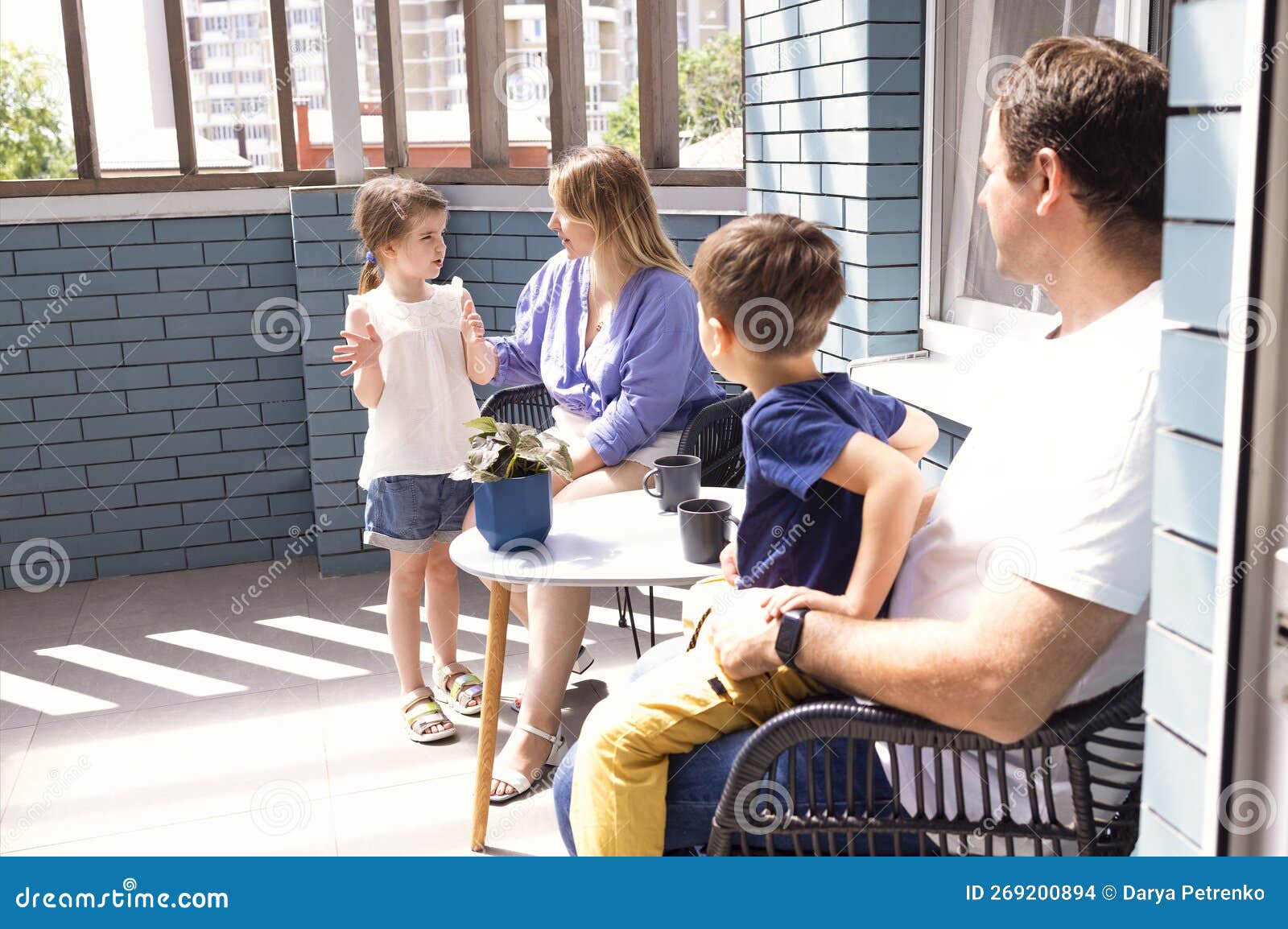 happy family having breackfast coffee on rooftop patio at home in the morning