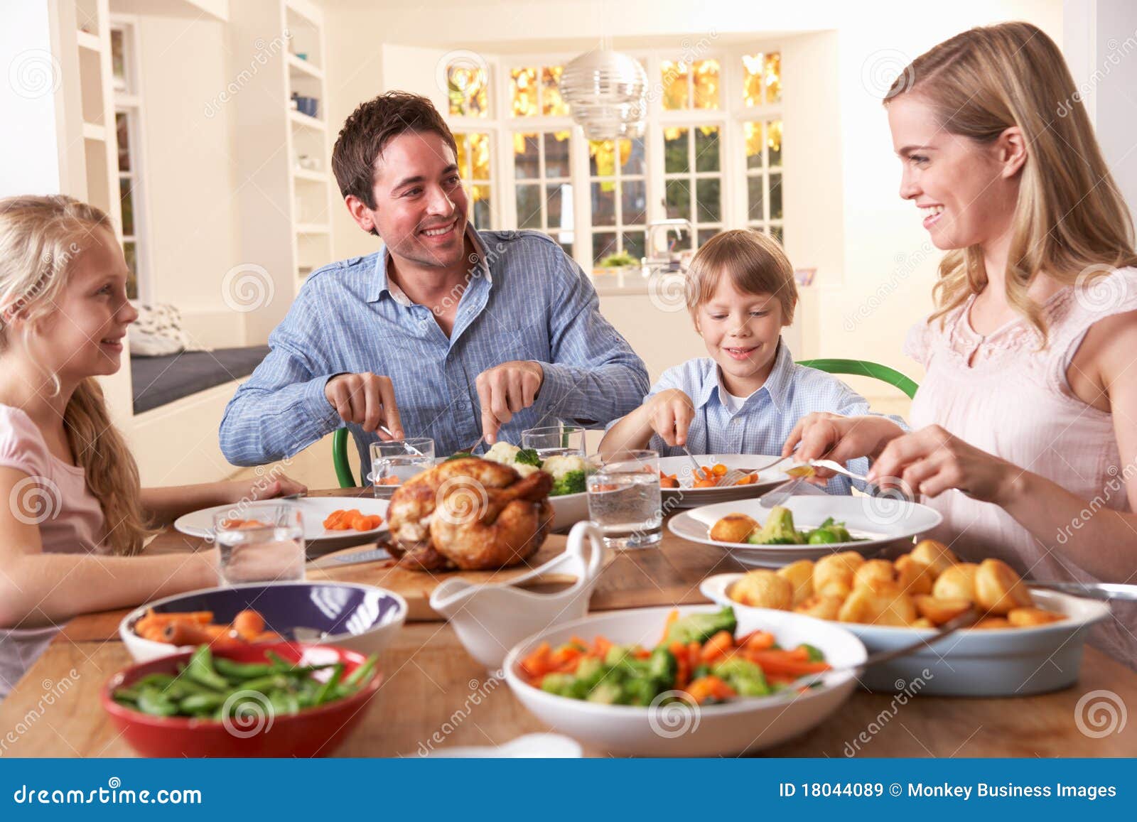 happy family having roast chicken dinner at table