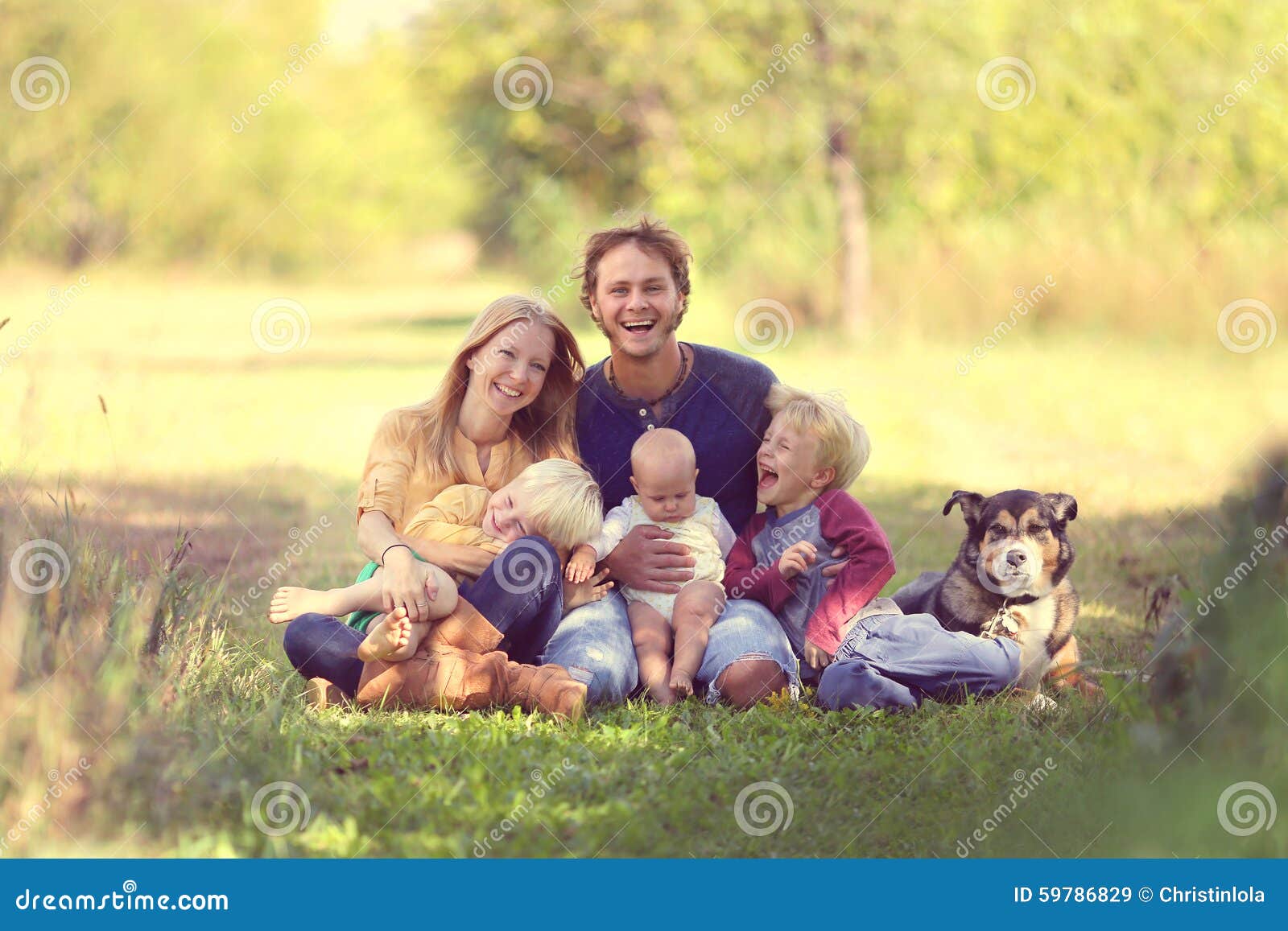 happy family laughing together with dog outside