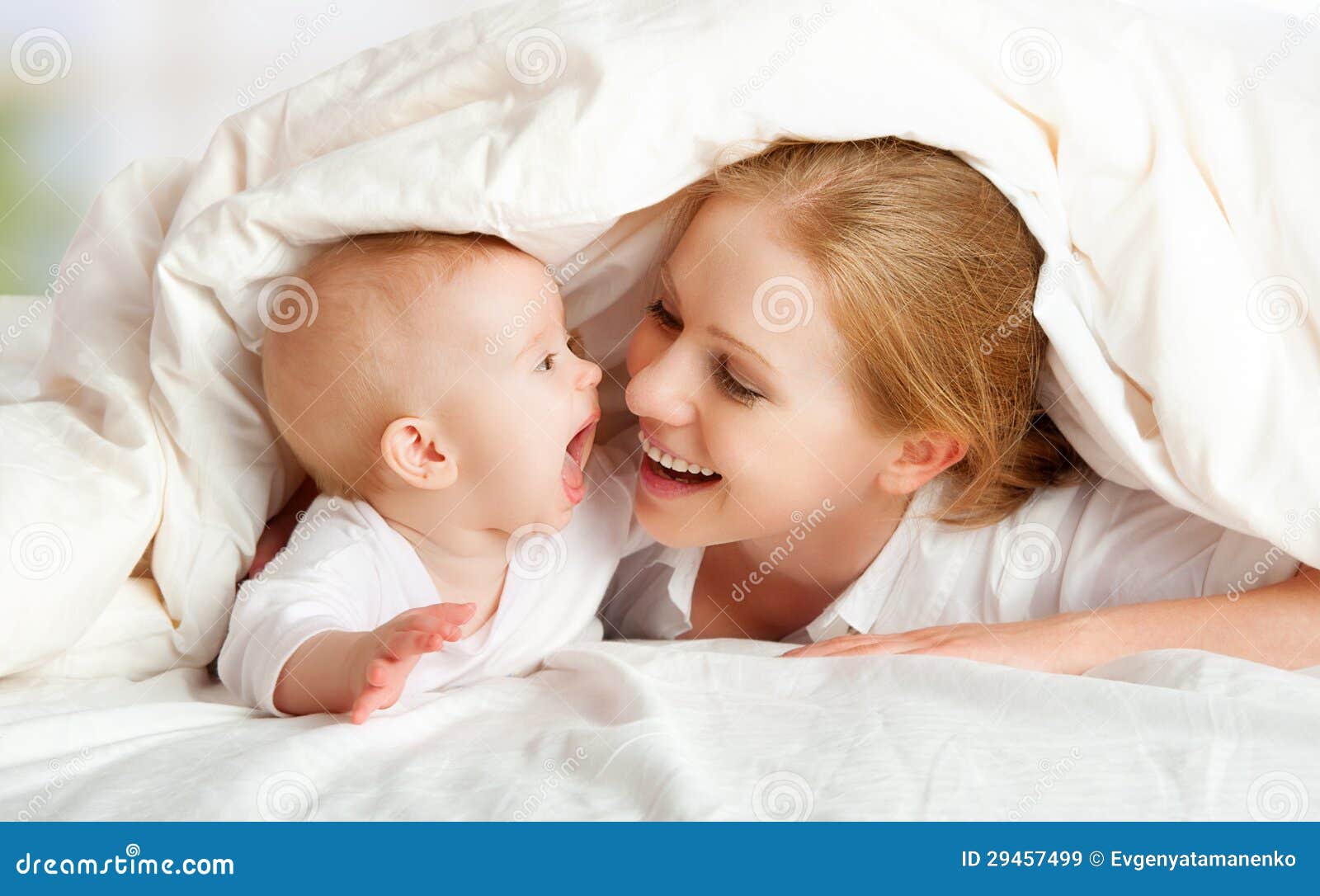 happy family. mother and baby playing under blanket