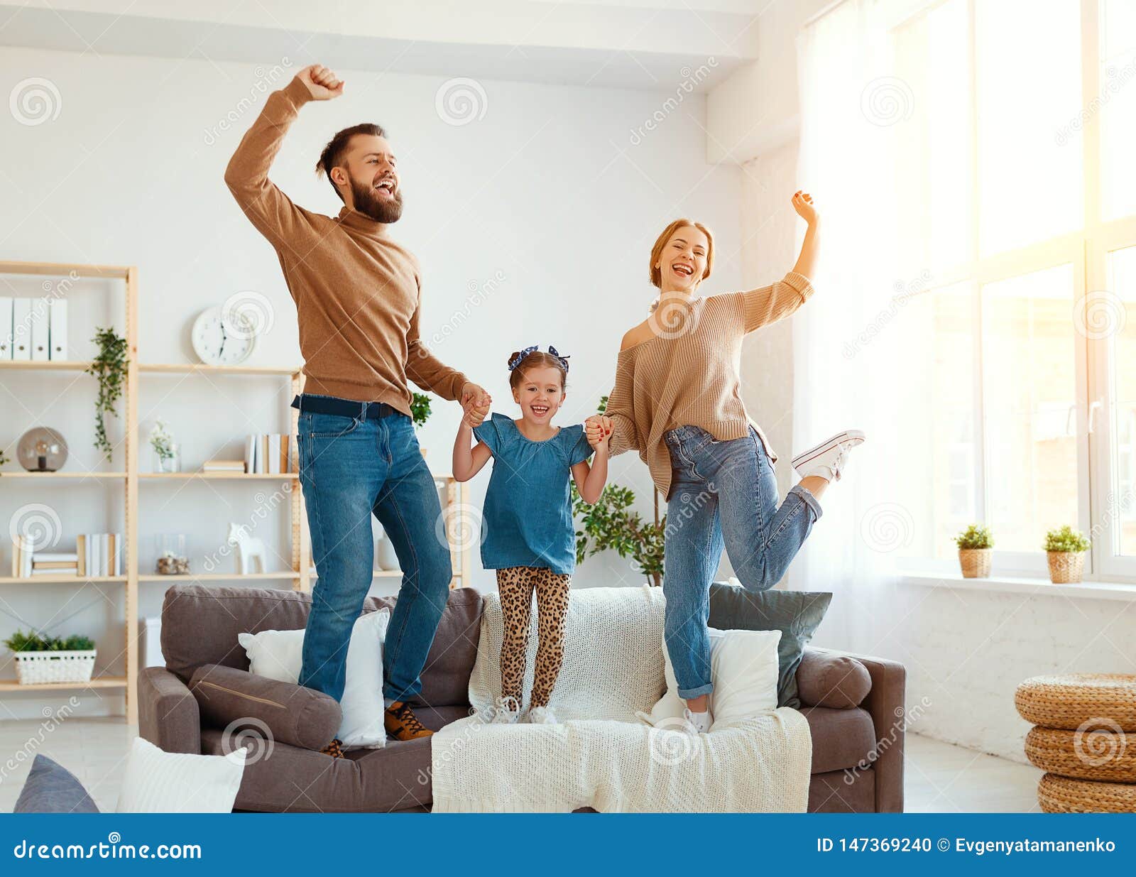 happy family mother father and child daughter dancing at home