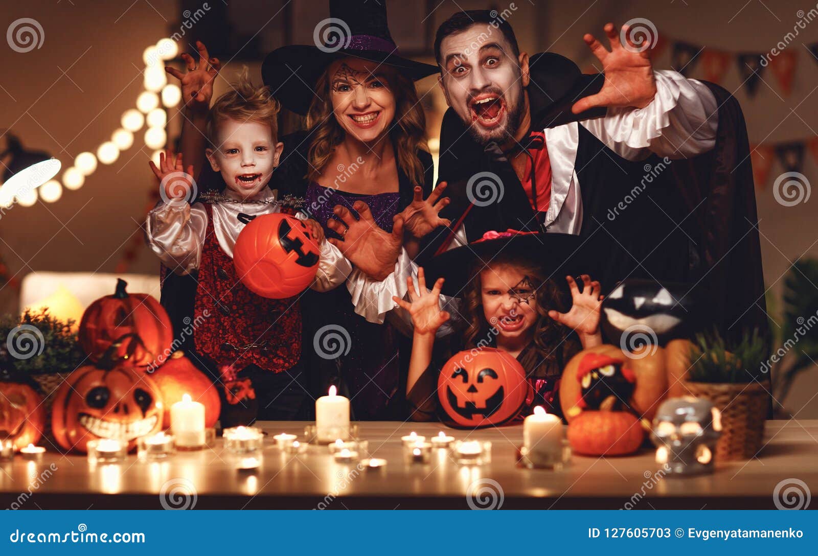 happy family mother father and children in costumes and makeup on a celebration of halloween