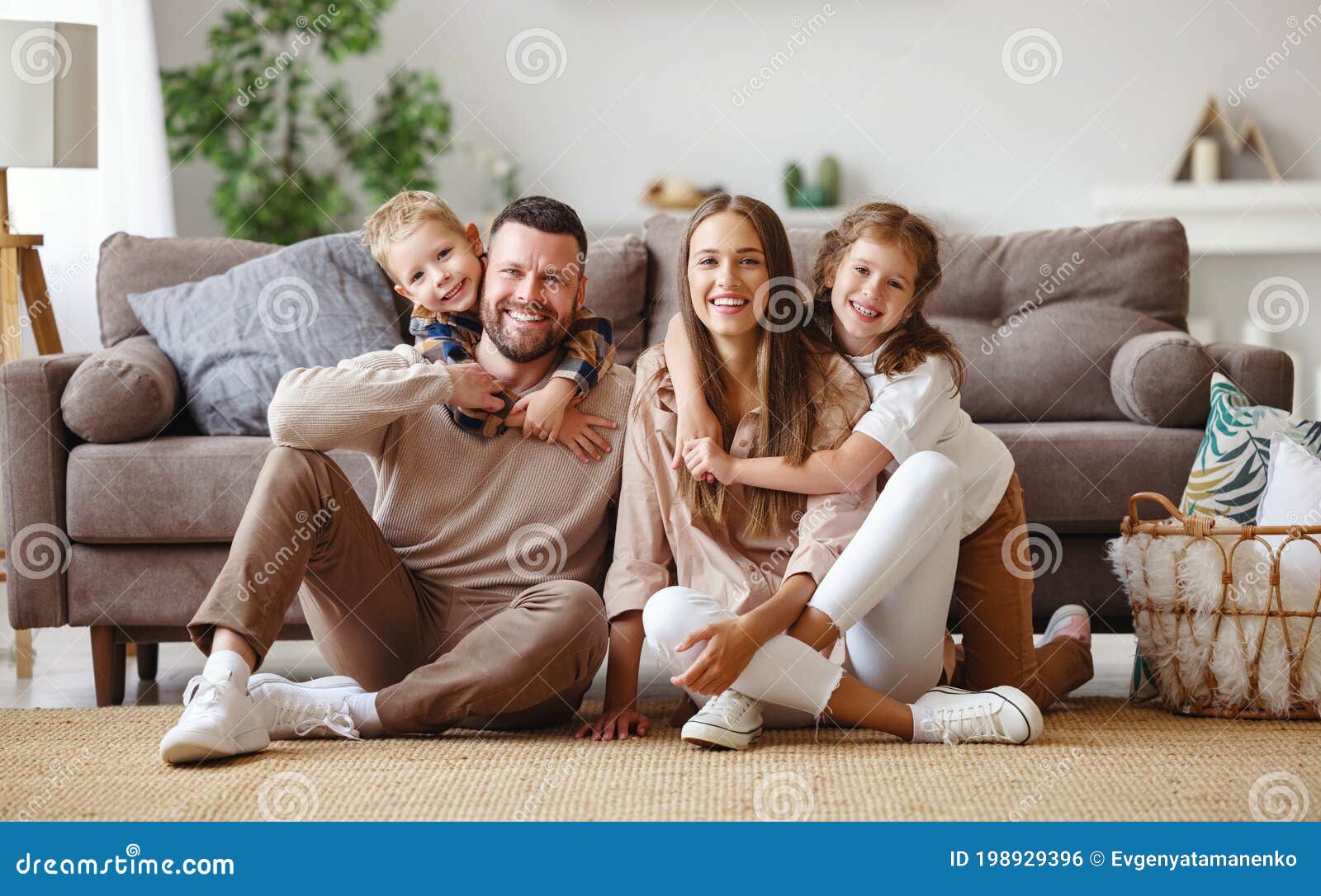 happy family mother father and children at home on couch