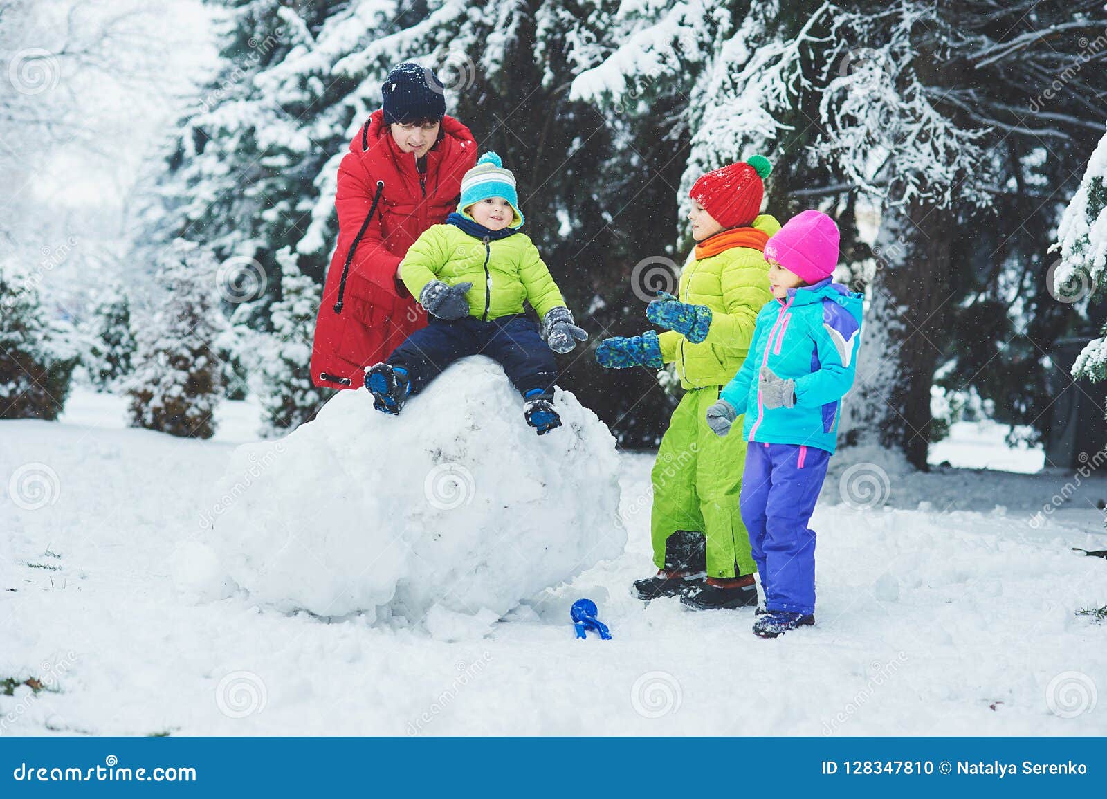 a happy family. mother and three children playing in the winter forest.