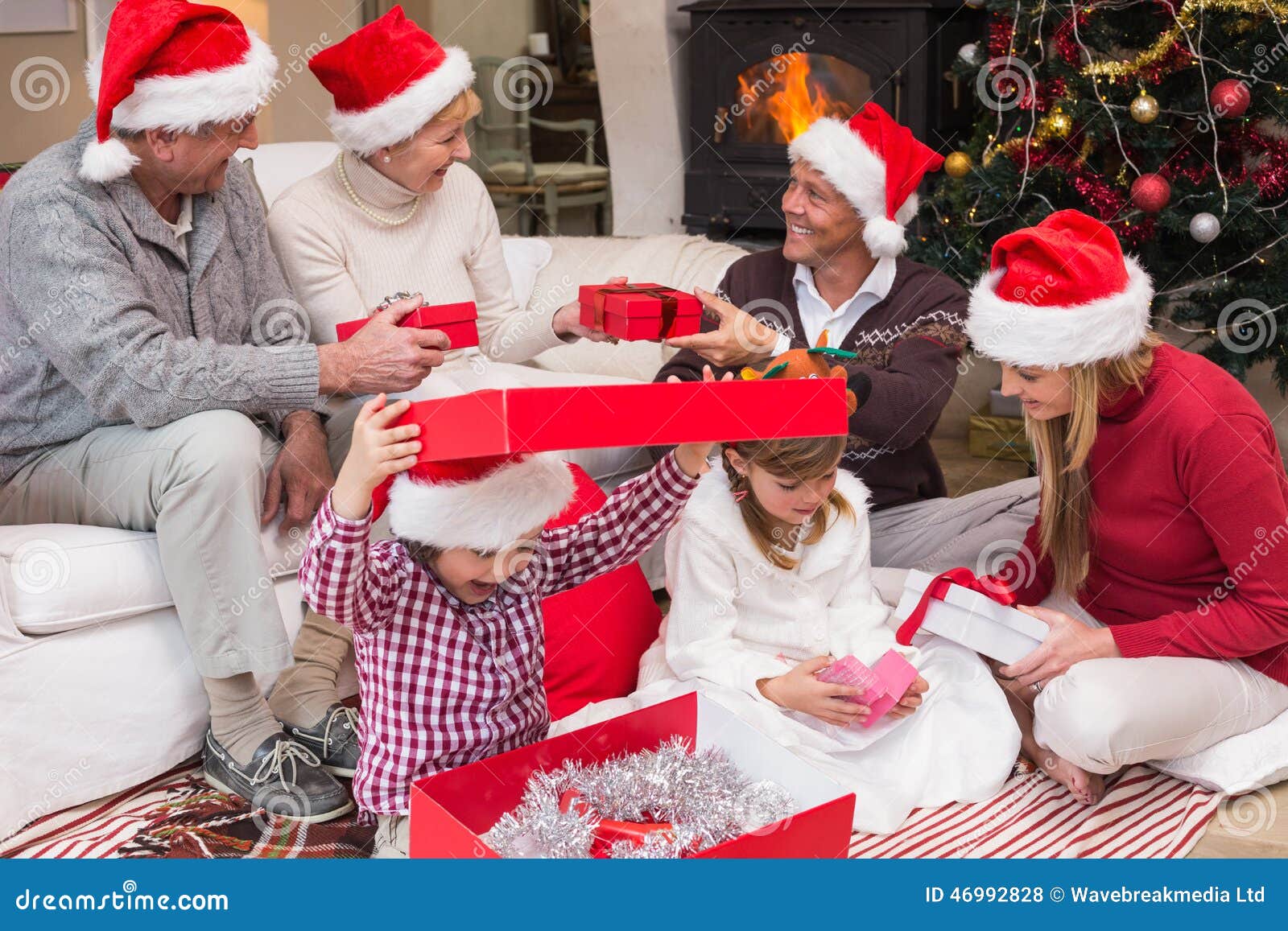 Happy family opening christmas gifts together at home in the living room