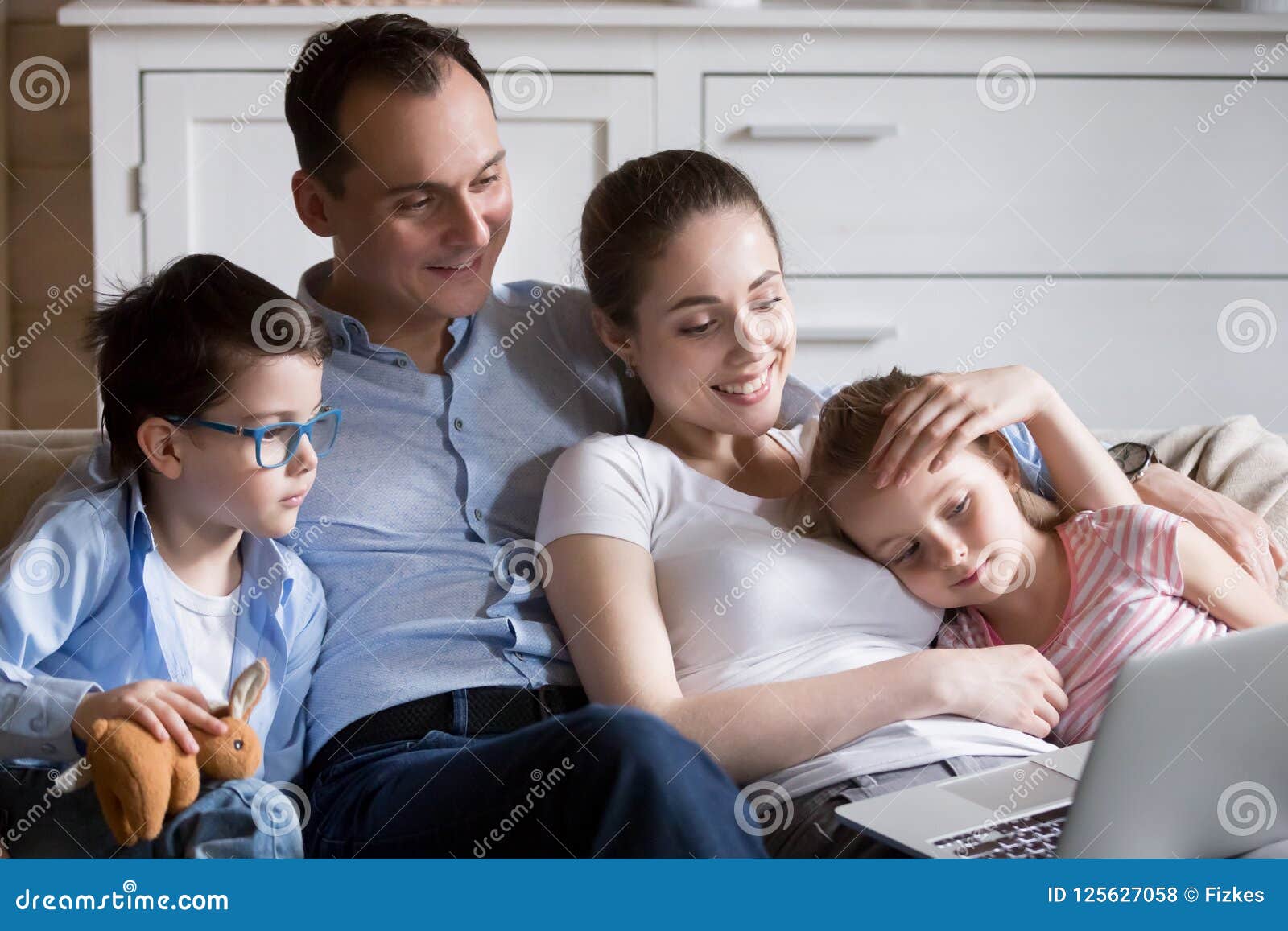 happy family relax in living room watching cartoons on laptop