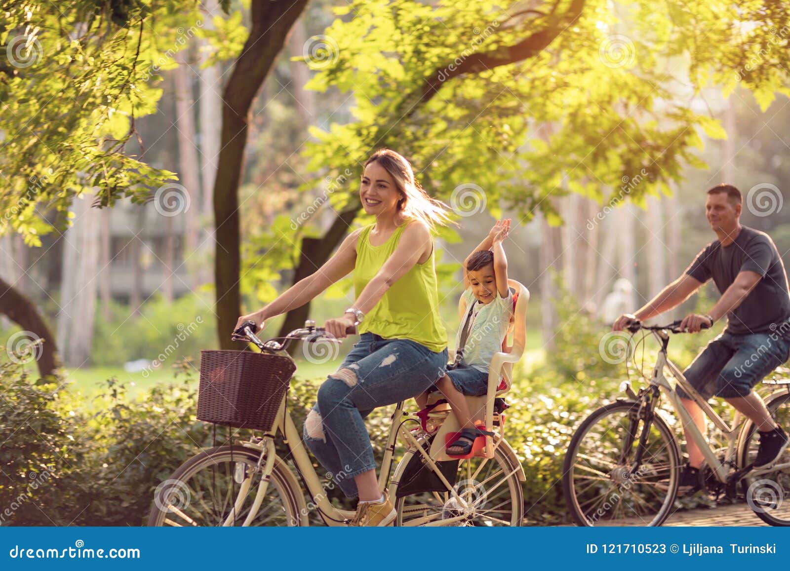 happy family is riding bikes outdoors and smiling- boy on bike w