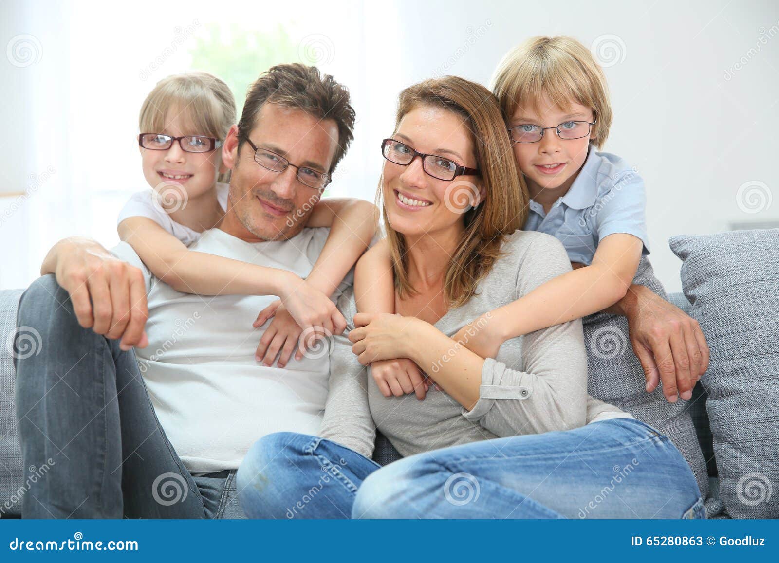 happy family sitting on sofa wearing eyeglasses
