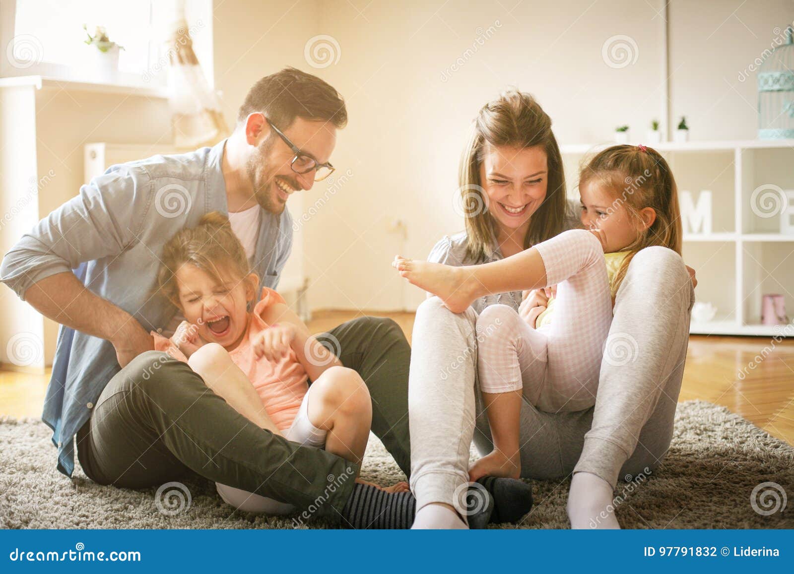happy family with two daughters playing at home.