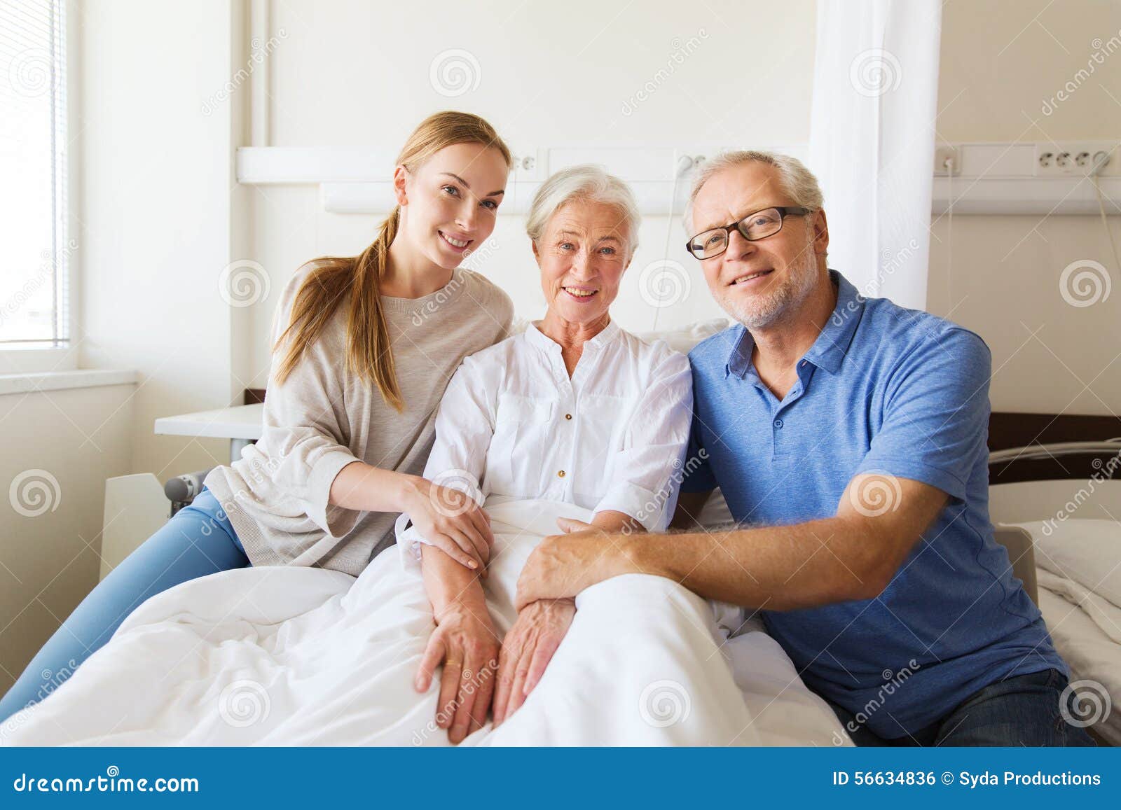 Happy Family Visiting Senior Woman At Hospital Stock Photo