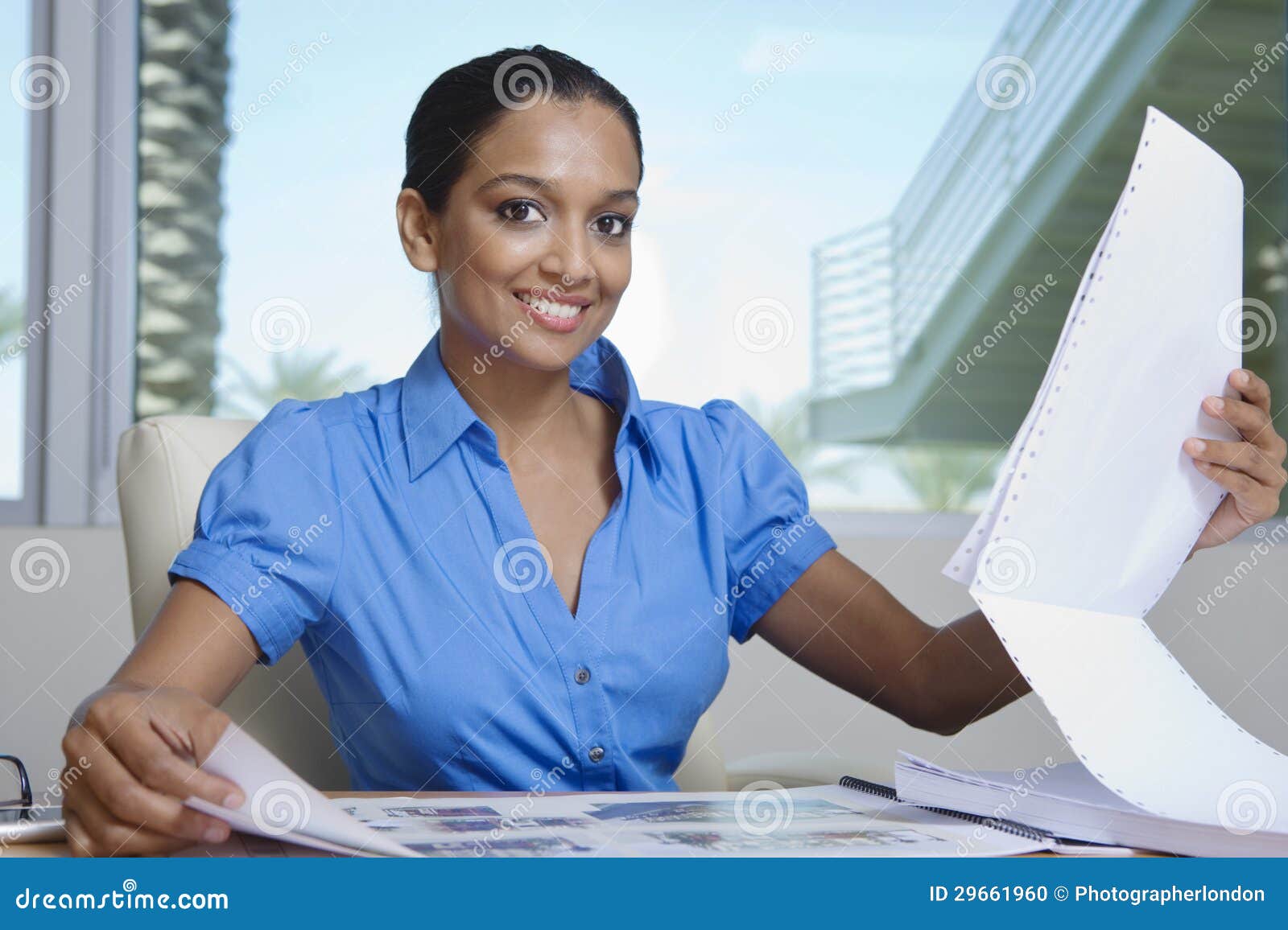 Happy Female Estate Agent Looking at Building Models Stock Photo