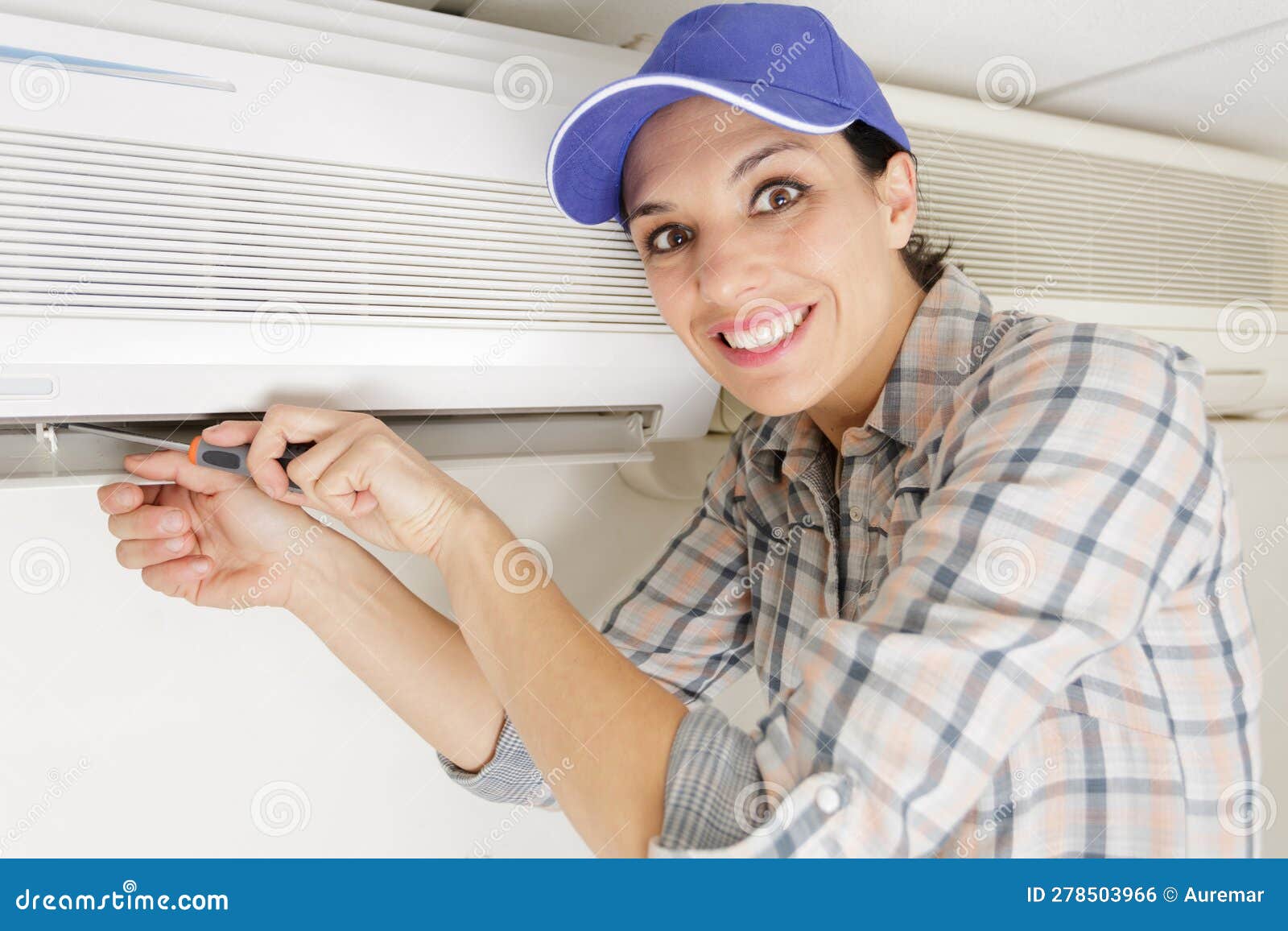 Happy Female Technician with Air Conditioning Cleanser Stock Photo