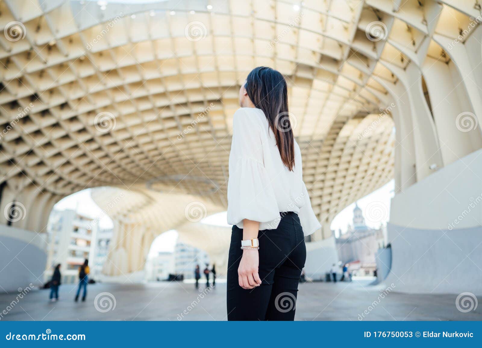 happy female tourist visiting setas de seville aka metropol parasol, site seeing attractions.vacation in south of spain.andalucia