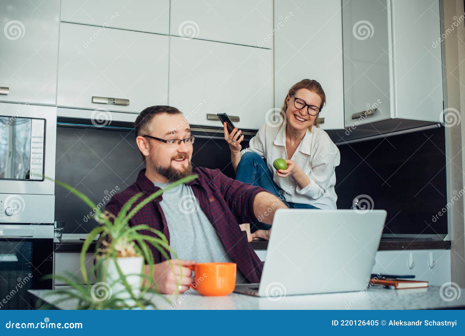 https://thumbs.dreamstime.com/z/happy-forty-year-old-married-couple-spending-time-together-home-kitchen-man-looks-laptop-points-monitor-220126405.jpg