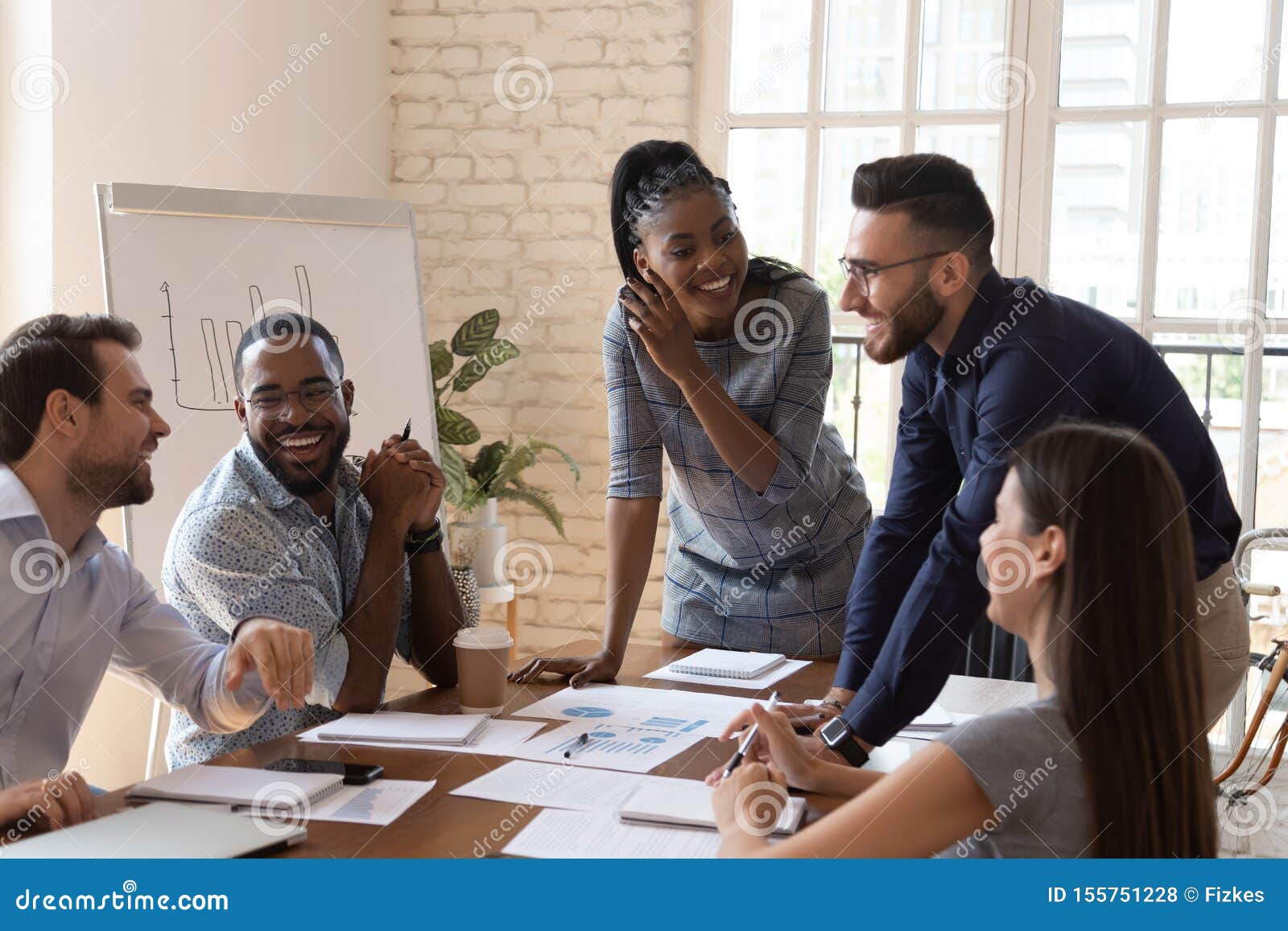 happy friendly multiracial team laughing working together at corporate briefing