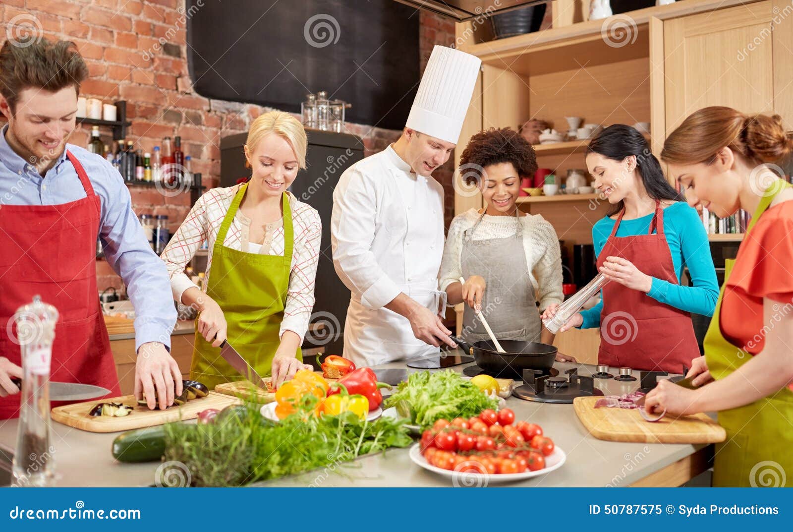 happy friends and chef cook cooking in kitchen