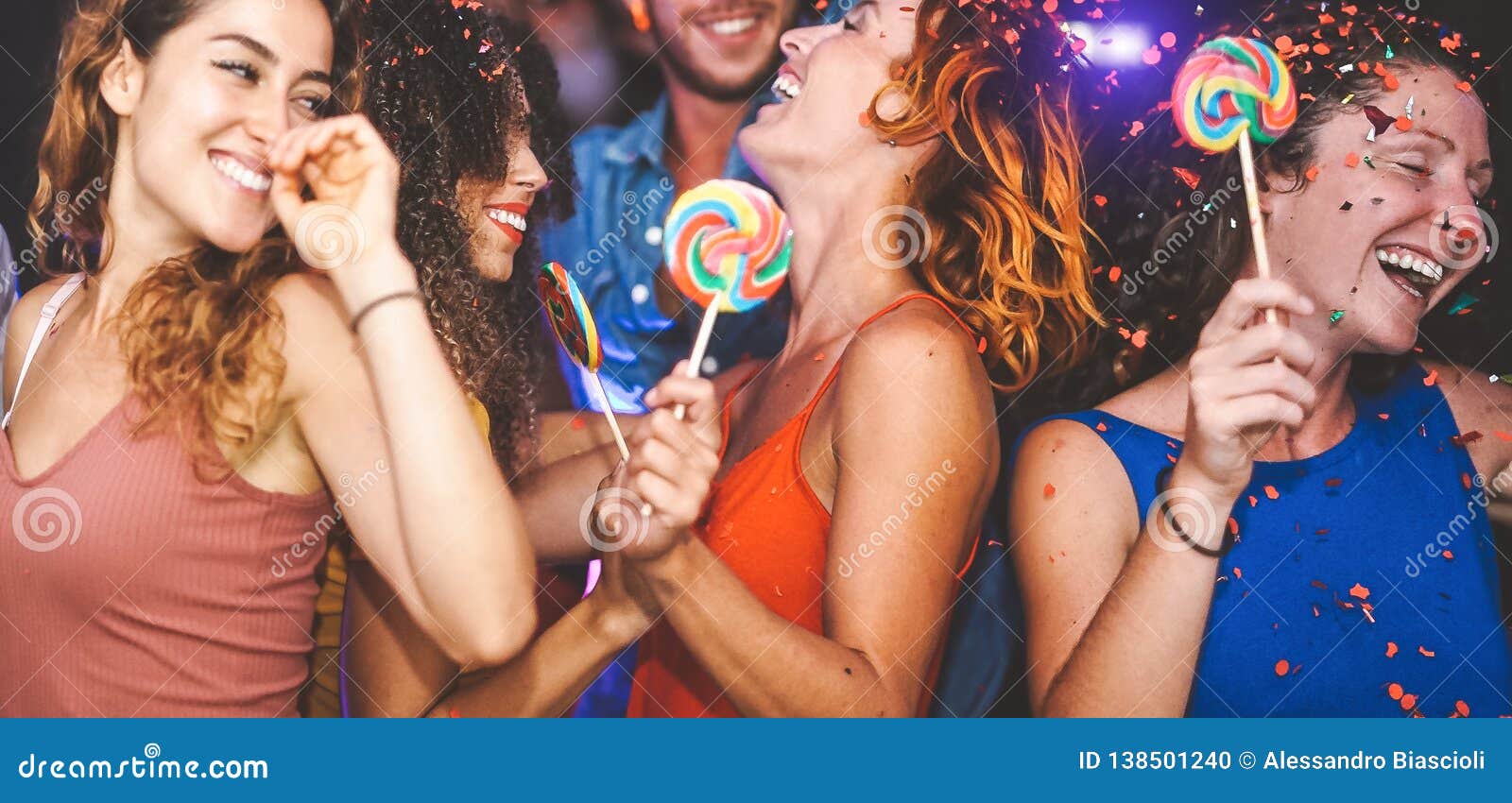 happy friends doing party dancing in the nightclub - trendy young people having fun celebrating together with confetti and candy
