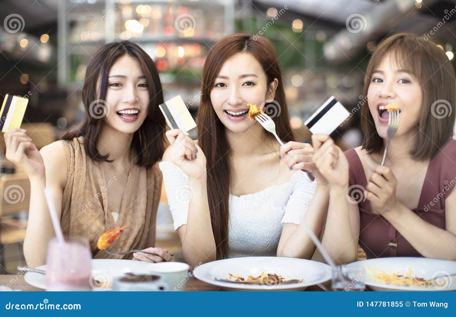 Friends Having Dinner And Showing Credit Card In Restaurant Stock Image