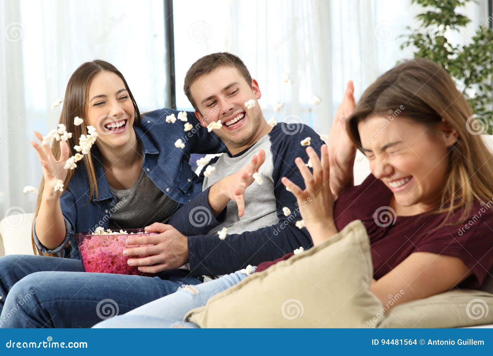 happy friends joking throwing popcorn