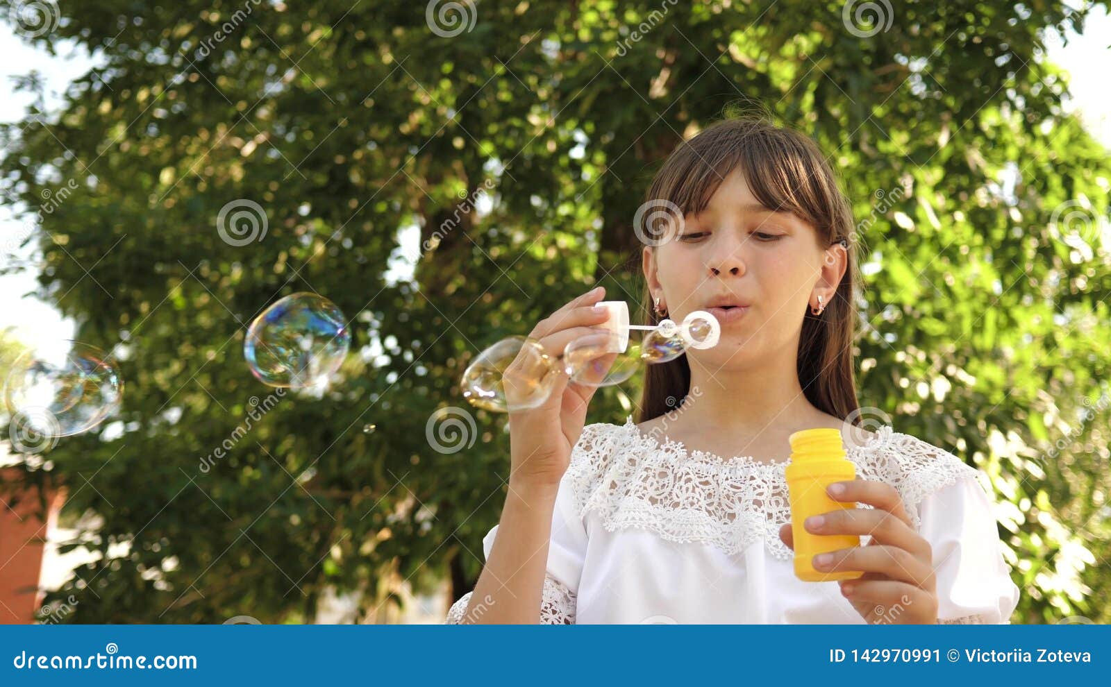 Happy Girl Blowing Beautiful Soap Bubbles In The Park In Spring Summer And Smiling Slow Motion