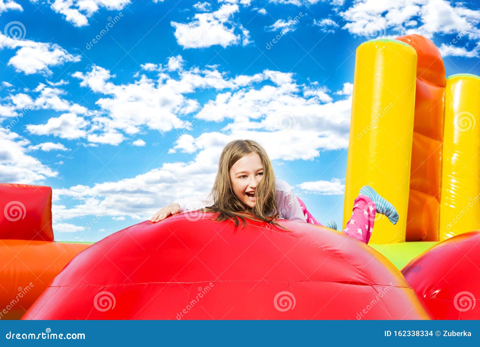 happy girl child on inflate castle cloudscape