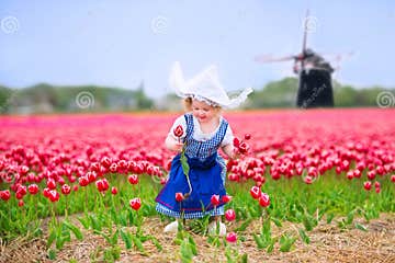 Happy Girl in Dutch Costume in Tulips Field with Windmill Stock Photo ...