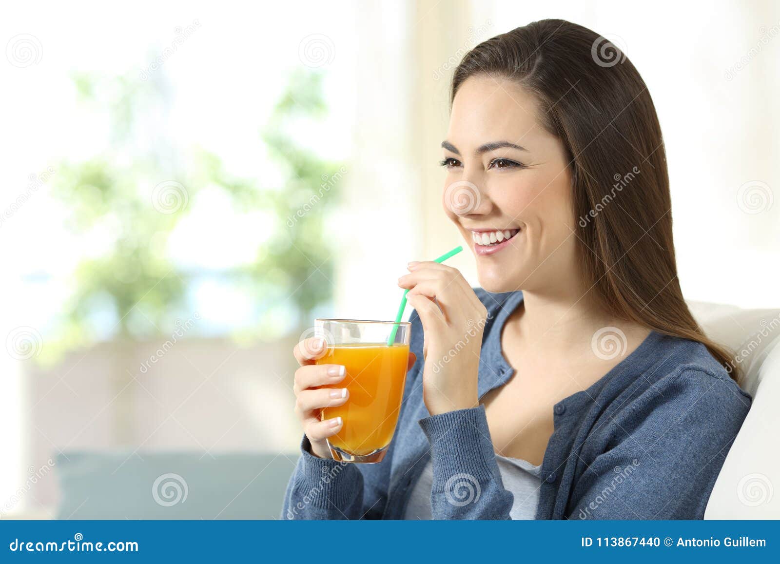 Happy Girl Holding an Orange Juice Glass at Home Stock Photo - Image of ...