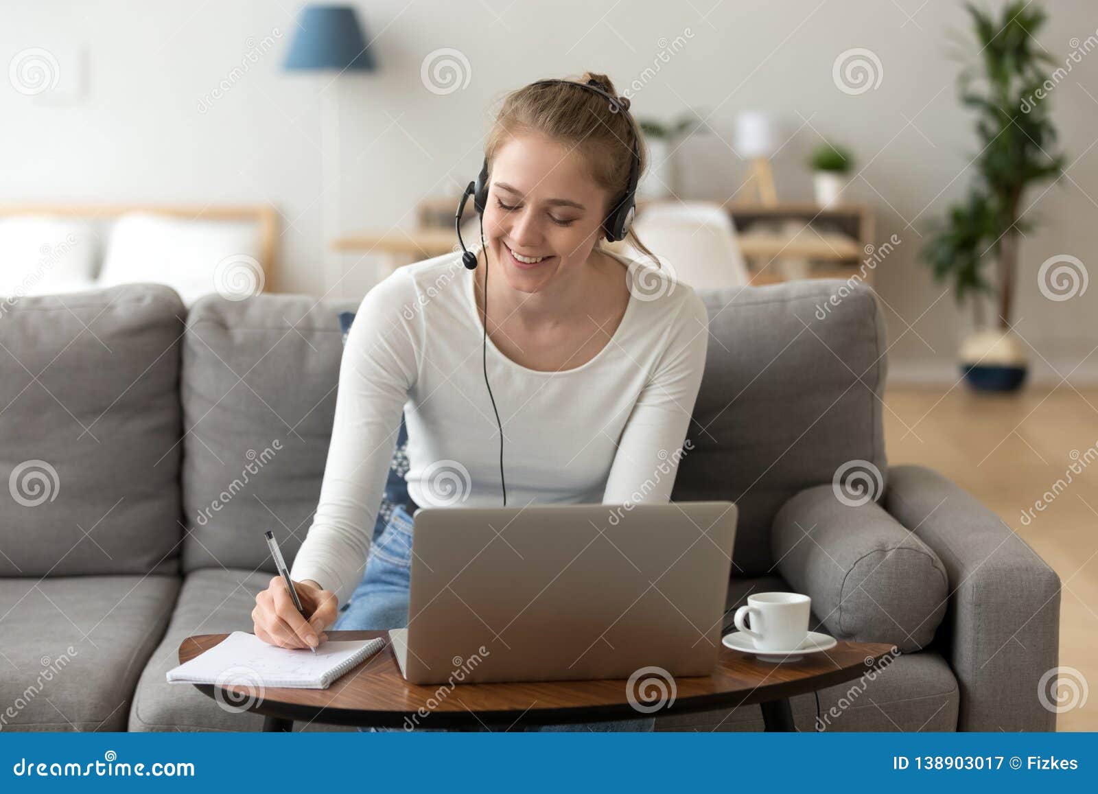 happy girl interpreter in headset write notes study on laptop