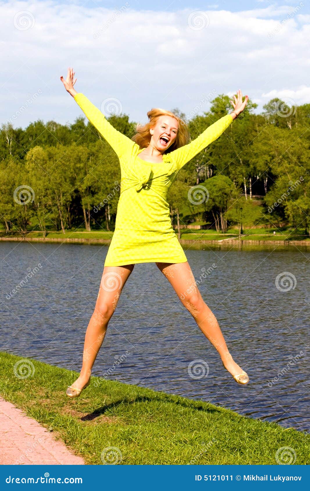 The Happy Girl Jumps on the Bank of the River Stock Image - Image of