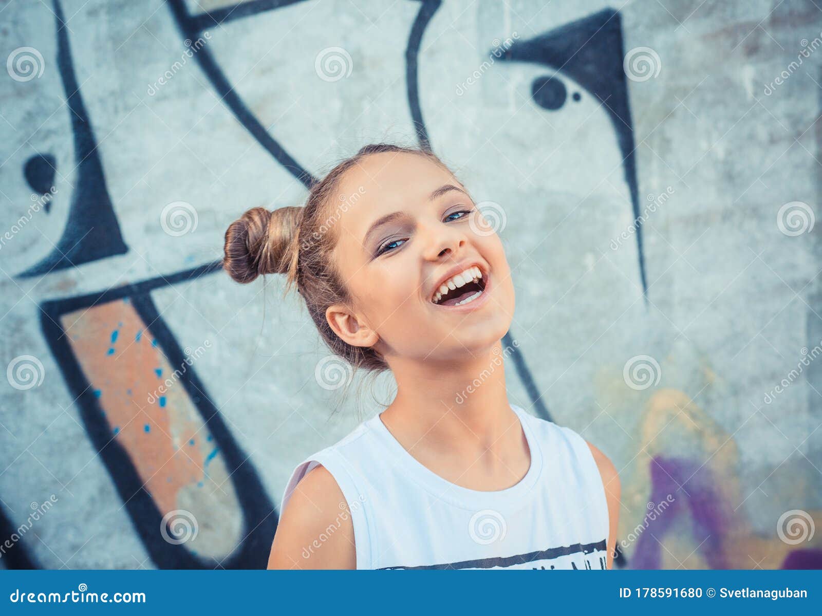 happy girl laughing against a colorful graffiti, graphiti background. concept of joy and happiness