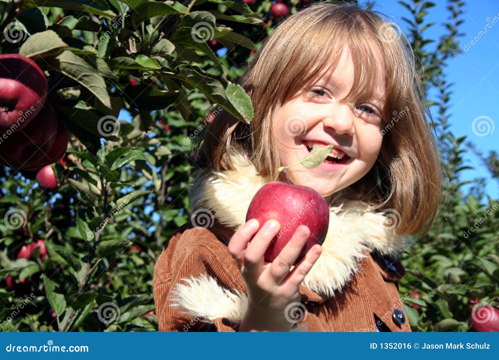 happy girl offers fresh apple