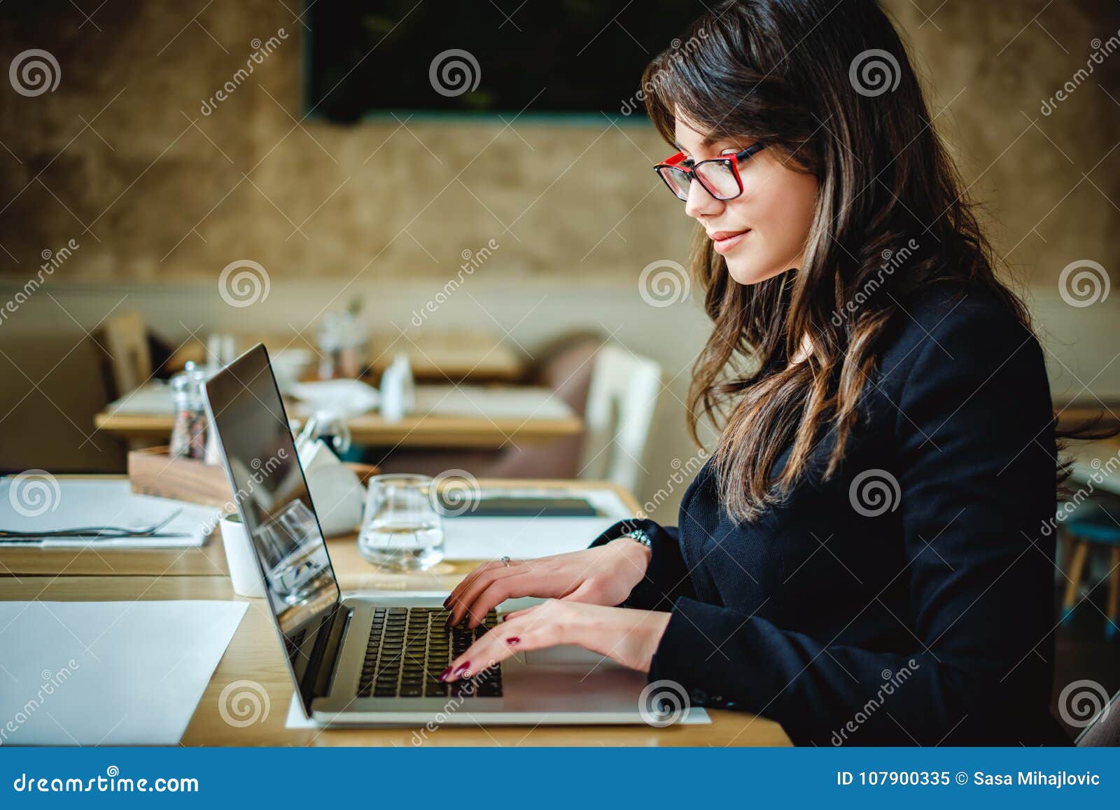 mixed race young woman typing on computer keyboard at table with