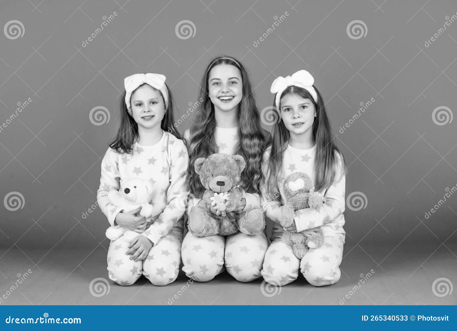 happy girls children holding teddy bears sitting together in homewear pink background, girlhood