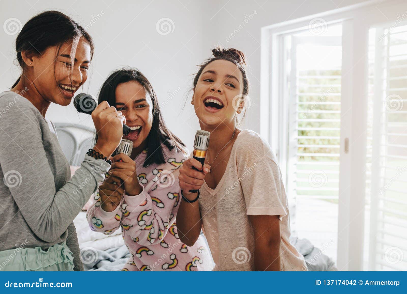 Three teenage girls laughing and having fun while lying on 
