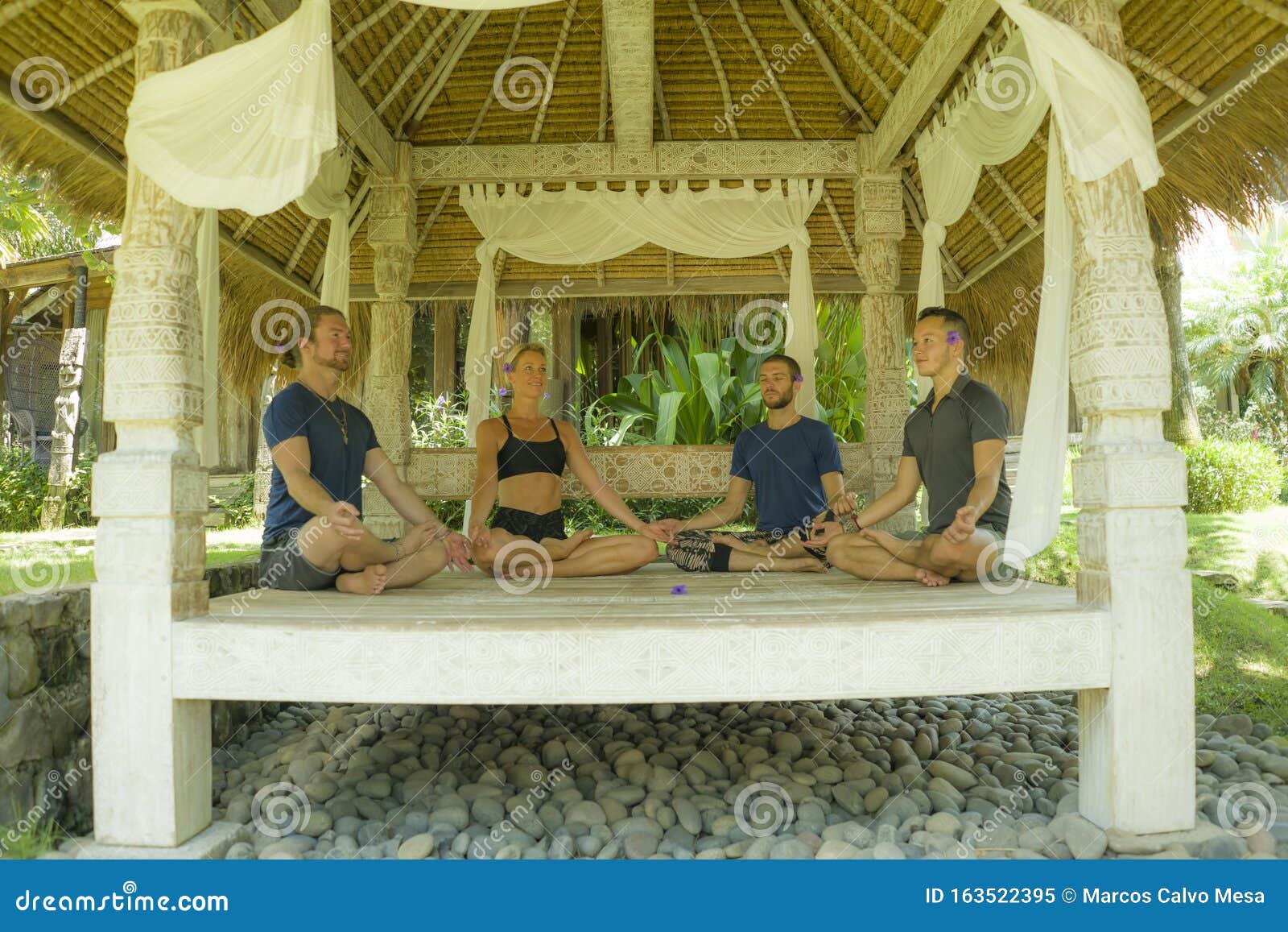 Group of three slim women sitting in lotus position on yoga mats