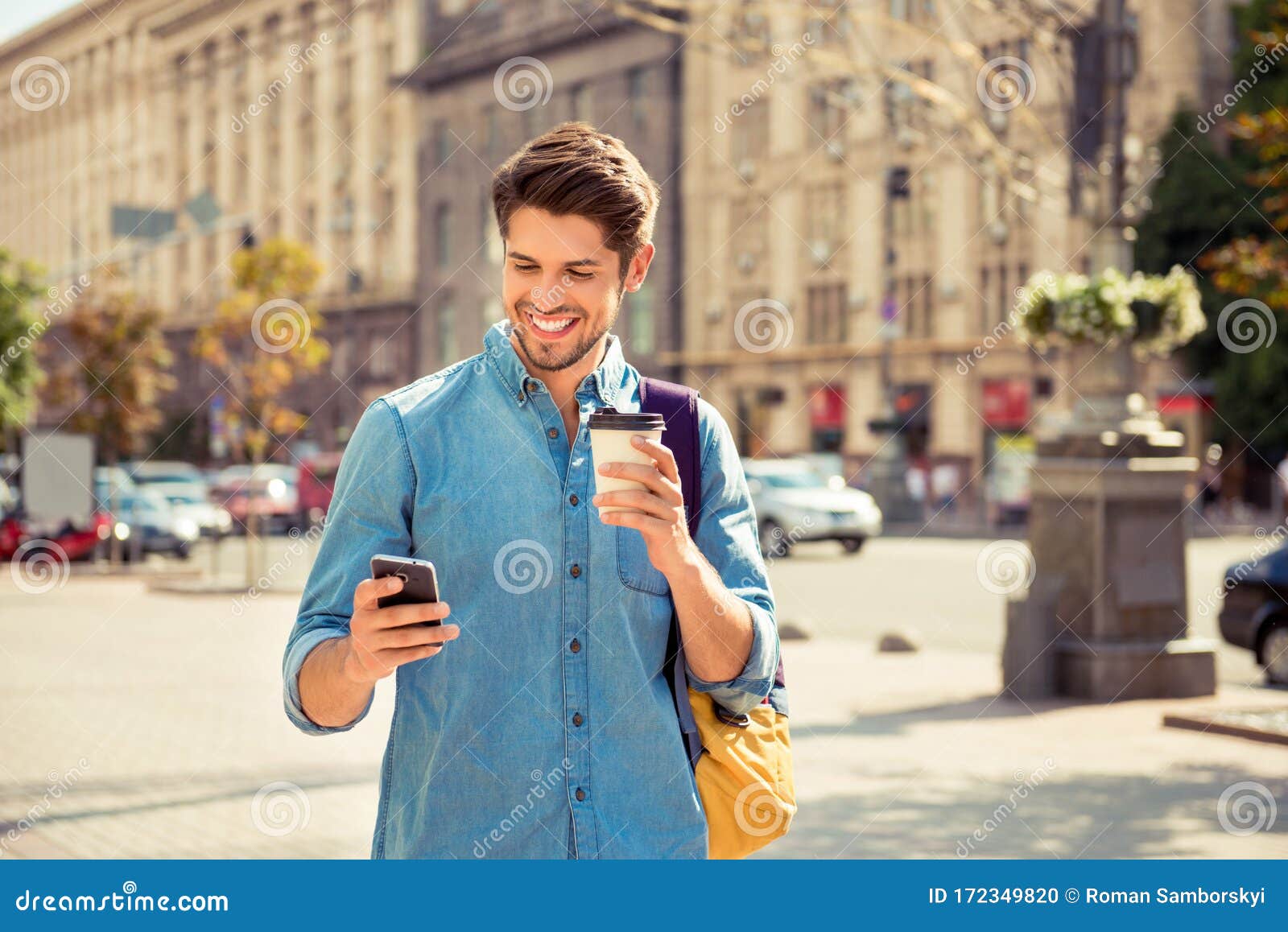 happy guy having walk in the city and typing sms