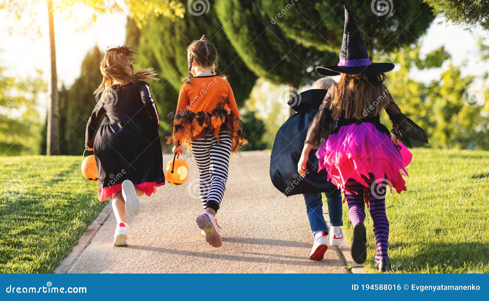 Happy Halloween! Funny Children in Carnival Costumes with Bucket Run Back  Along the Path in the Garden Stock Photo - Image of park, children:  194588016