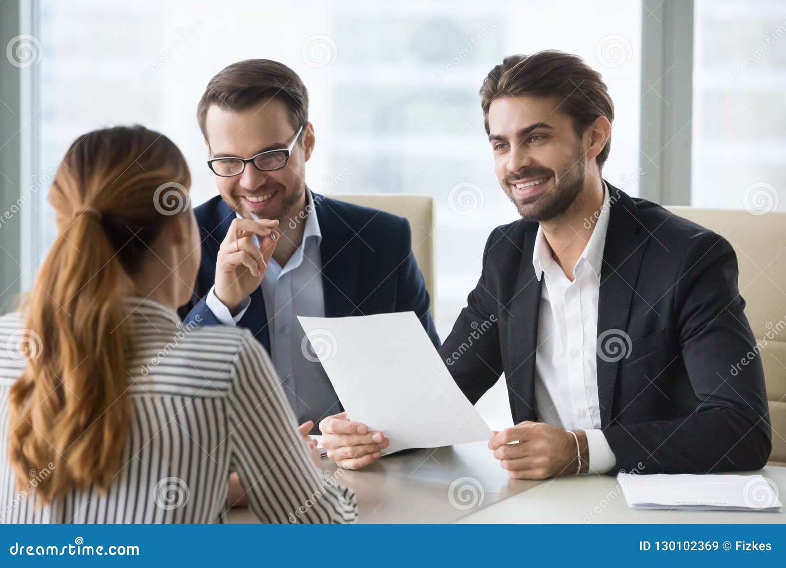 happy hr manager with resume looking at female job seeker.