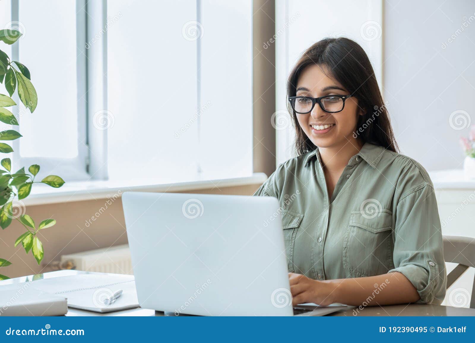 happy indian young woman using laptop computer work study at home office.