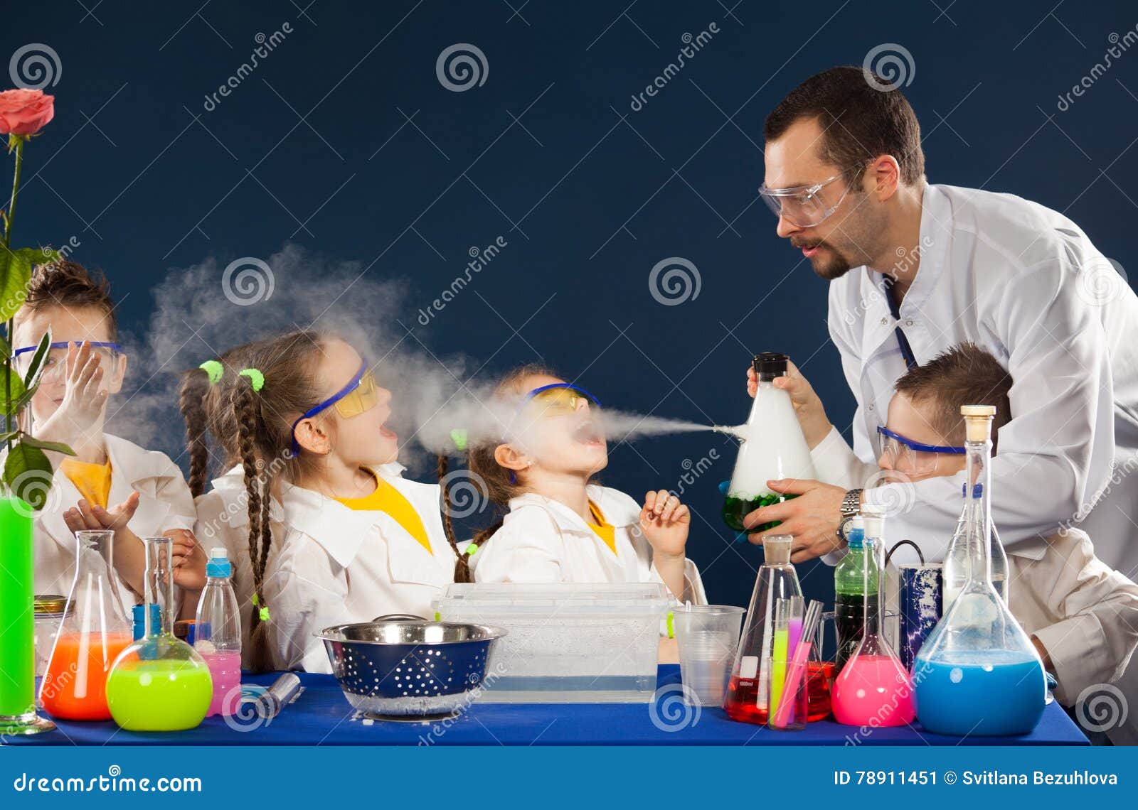 happy kids with scientist doing science experiments in the laboratory