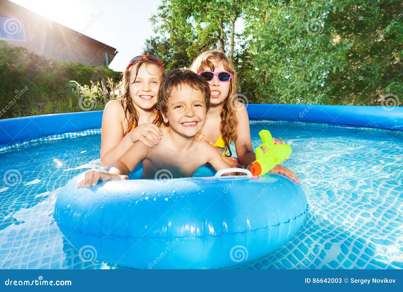 happy kids swimming in the pool with rubber ring