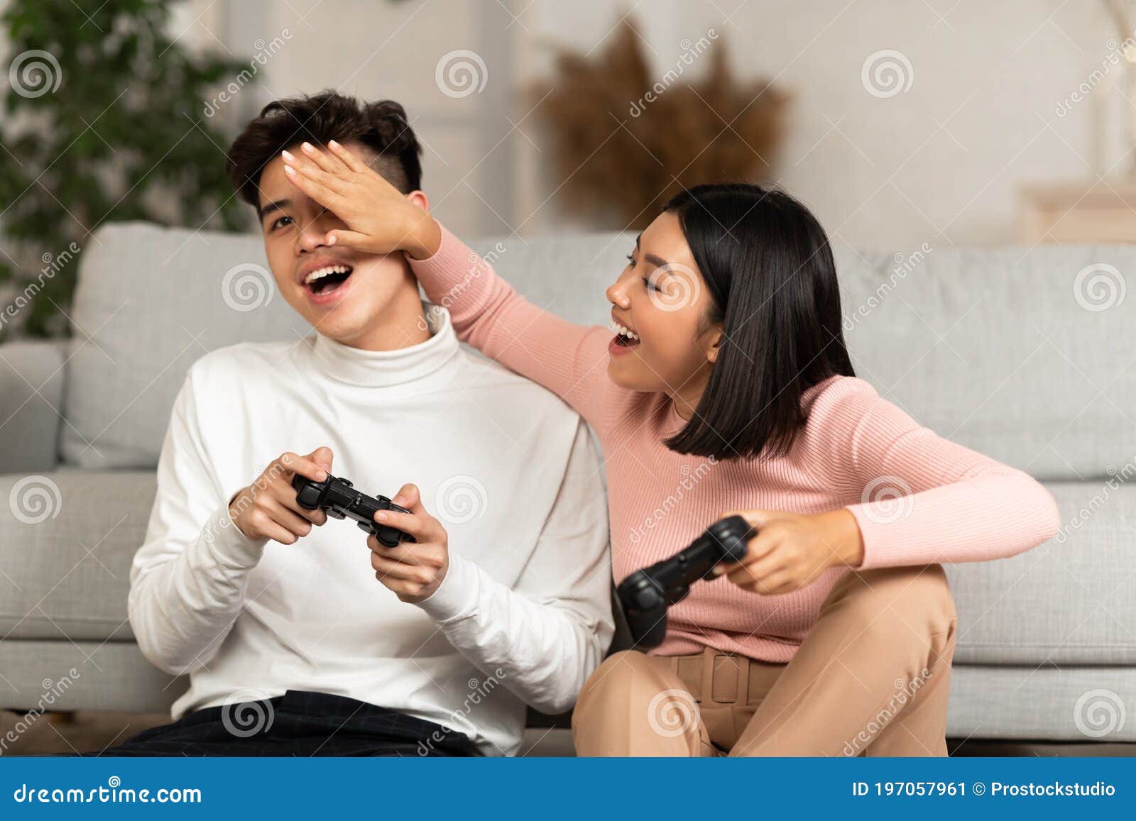 Happy boyfriend and girlfriend playing video games and holding