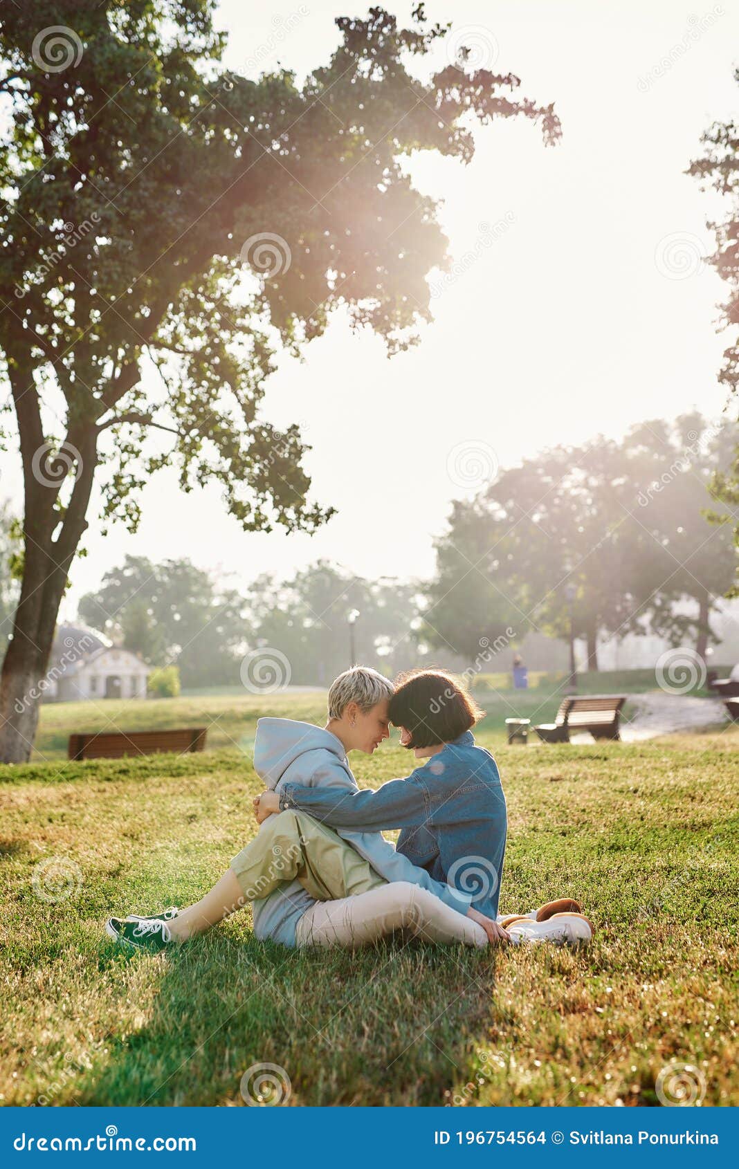 Happy Lesbian Couple Sitting On The Grass In Summer Park Women In Love